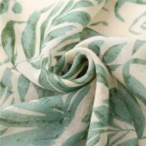 Macro detail of breathable cotton-linen fabric with green tropical leaf print