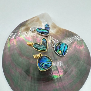 18K gold plated heart and oval shell pendants displayed on a natural abalone shell