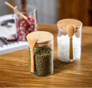 Detail view of glass storage jars with bamboo lids and spoons holding sugar and mung beans