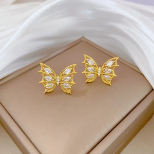 Gros plan de boucles d'oreilles papillon en acier titane avec cristaux brillants