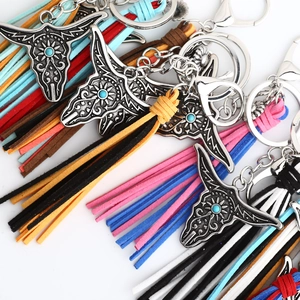 Detail of western bull head metal keychains with colorful faux suede fringe tassels