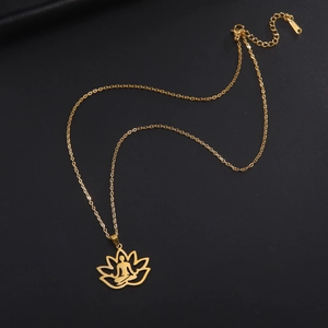 Detail view of a gold lotus pendant with a meditating figure on a dark leather texture