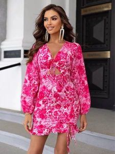 Robe courte rose à fleurs avec col en V, manches longues, découpe et ourlet à volants