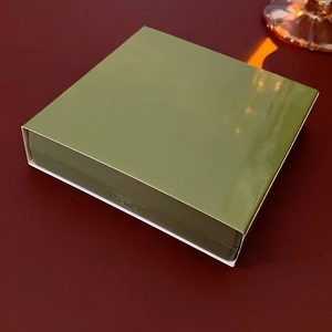 Detail showing the green push-to-open mechanism of a square floating jewelry box