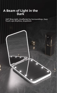 Detail of white foldable LED makeup mirror with 8 built-in lamp beads on marble surface