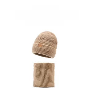 Dettaglio del set cappello e scaldacollo in maglia marrone chiaro con fodera in pile