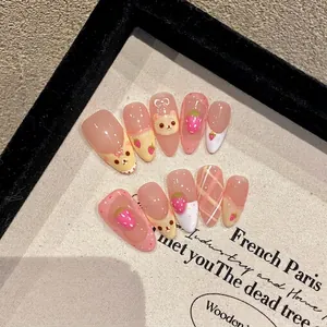 Handmade press-on nails featuring cute cartoon bear and strawberry 3D designs