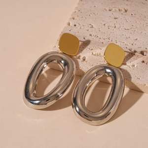 Minimalist oval geometric earrings with gold studs and silver hoops in a high-gloss finish
