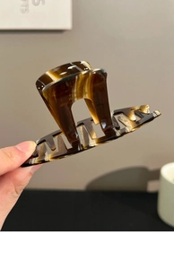 Close-up of brown tortoise shell acrylic hair claw clip with France Handmade lettering