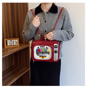 Detail of red vintage TV shaped bag featuring a retro no signal screen and glossy finish