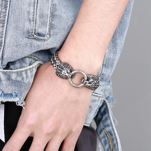 Macro shot of punk style lion head bracelet in vintage silver finish on a denim jacket