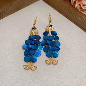 Detail of golden fish earrings with blue sequins and blue enamel eye accents