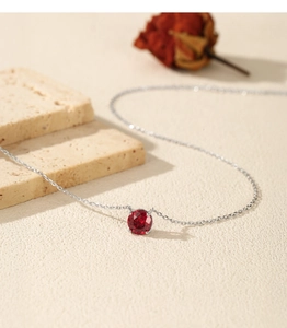 Detailed view of S925 silver necklace featuring a round pomegranate red gemstone pendant