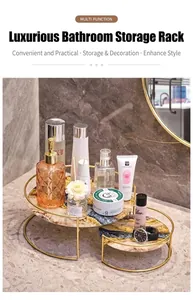 Detalle de estante de baño dorado de dos niveles con bandejas de mármol en el lavabo