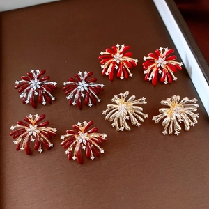 Macro shot of vintage firework flower earrings with zircon in red and gold finish