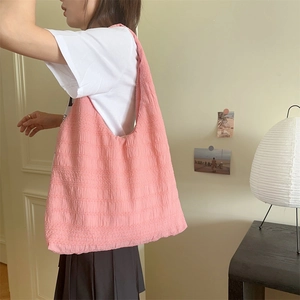Detailed texture of pink bubble-crinkle tote bag showing large capacity for daily commute