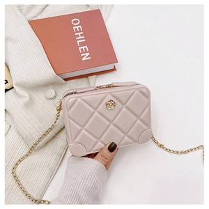 Detailed close-up of pink quilted PVC jelly bag with gold camellia clasp and chain strap