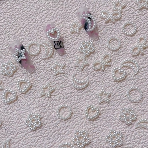 3D resin pearl nail art charms in heart, star and moon shapes on decorative false nails
