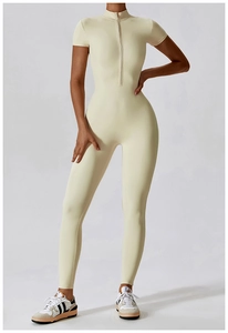 Detailed view of the 1/4 zip collar and short sleeve design on a beige yoga jumpsuit