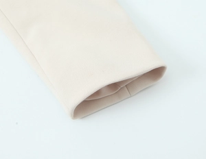 Dettaglio del polsino del blazer color crema con cuciture di qualità e tessuto a trama