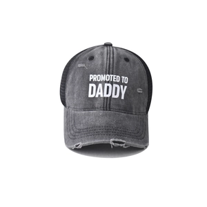 Close-up of 'PROMOTED TO DADDY' print on distressed grey cotton baseball cap with mesh back