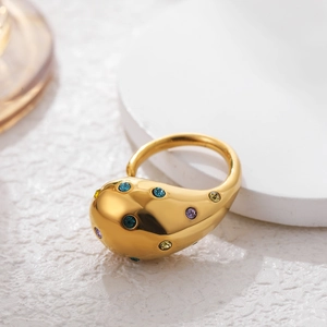 Macro detail of gold teardrop ring featuring colorful zircon stones in a modern design
