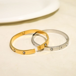 Detailed close-up of gold and silver stainless steel bangles with sparkling crystals