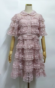 Detailed view of pink lace layering, beaded Peter Pan collar and ruffled skirt tiers