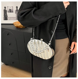 Silver leaf shell-shaped metal evening bag with pearl handle and chain strap on model