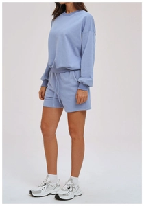 Detail of light blue sweatshirt set showing ribbed cuffs and drawstring shorts pockets