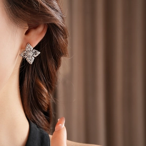 Close-up of vintage镂空flower stud earrings with sparkling cubic zirconia on model ear