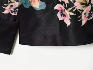 Detailed close-up of floral satin fabric with premium stitching and silky texture