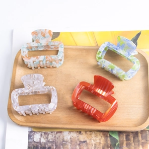 Set of four stylish 6cm PVC hair claw clips in marble and floral patterns for women