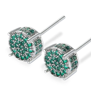 Close-up of four-claw silver stud earrings with cluster of micro-pave green zircons