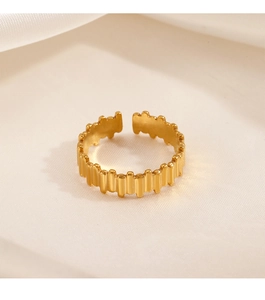 Gros plan sur bague ajustable plaquée or 18K avec texture striée sur fond de tissu doux
