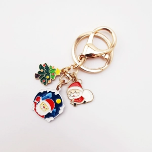 Detail of Christmas keychain with enamel charms featuring Santa Claus and a tree