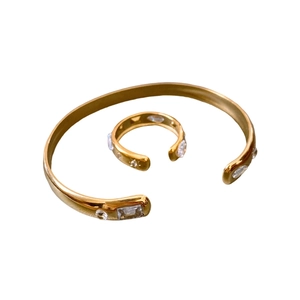 Gold-plated stainless steel jewelry set featuring a teardrop zircon ring and open cuff bracelet