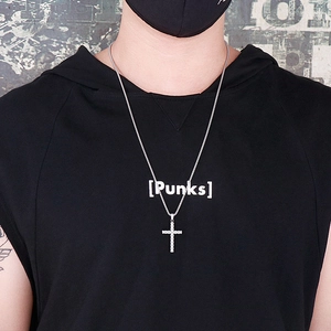 Gros plan d'un collier avec pendentif croix en acier inoxydable porté par un modèle