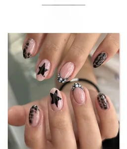 Close-up of short round press-on nails with black stars and leopard print pattern