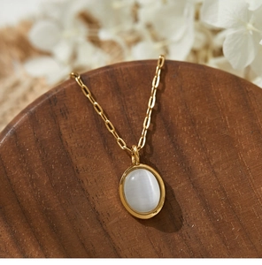 Makroaufnahme einer ovalen weißen Katzenauge-Kette mit 18K Goldbeschichtung