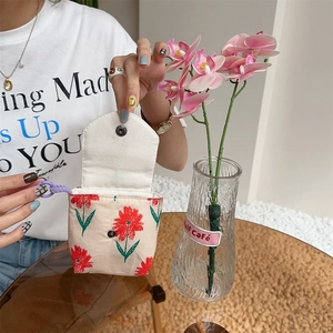 Detail of floral canvas storage bag with metal snap closure and purple wrist strap