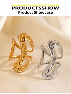 Detailed view of hammered gold and silver S-shaped wavy rings on beige silk fabric