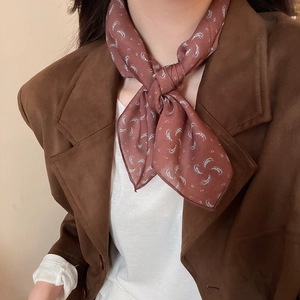 Detail showing paisley print fabric scarf necklace styling on a brown blazer outfit