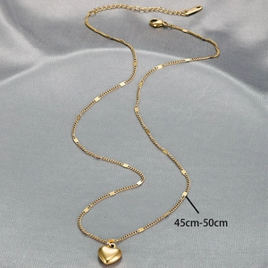 Detailed view of golden heart pendant necklace with 45-50cm adjustable chain on satin