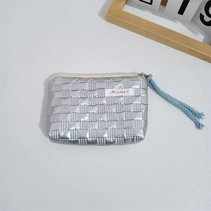 Close-up of quilted silver PU leather coin purse with metallic gloss and blue rope puller