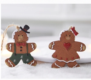 Close-up of cute Christmas gingerbread man resin ornaments on artificial snow surface