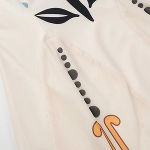 Macro detail of abstract floral print on soft white mesh fabric of a bohemian style dress