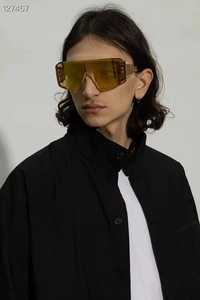 Front view of a model wearing gold frame steampunk sunglasses with yellow lenses