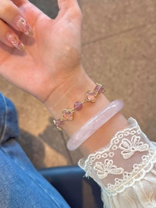 Détails des perles de cristal rose et trèfles sur un bracelet empilable pour femme