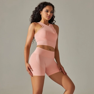 Detail of peach pink seamless ribbed texture on racerback tank top and yoga shorts